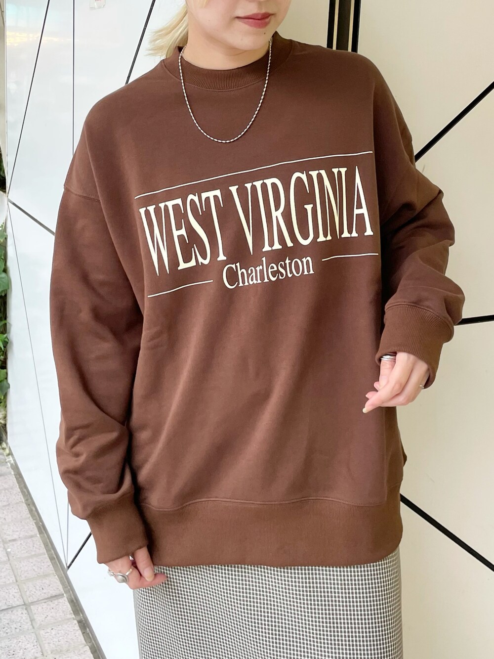 ブラウン系のスウェット、ブラック系のスカートを着用したレディースの秋コーディネートの3枚目の写真