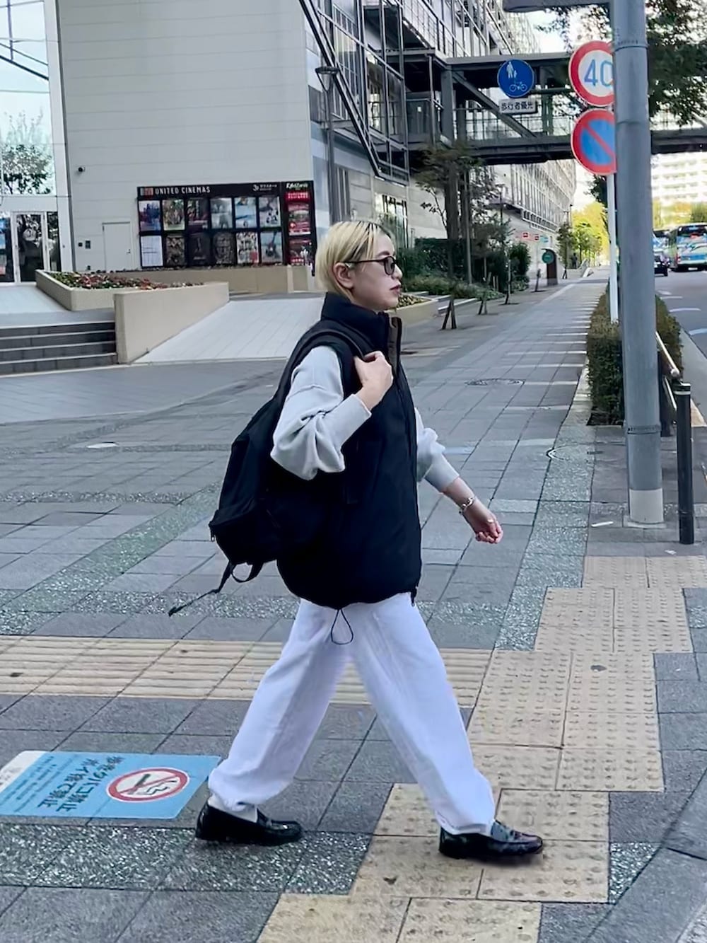 ブラック系のダウンベスト、ホワイト系のニット/セーター、グレー系のスウェットパンツを着用したレディースの冬コーディネートの4枚目の写真