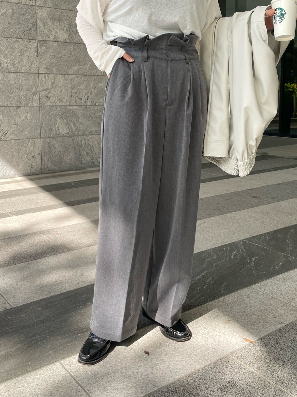 ホワイト系のジャケット/アウター、ホワイト系のTシャツ/カットソー、グレー系のスラックスを着用したレディースの秋コーディネートの10枚目の写真