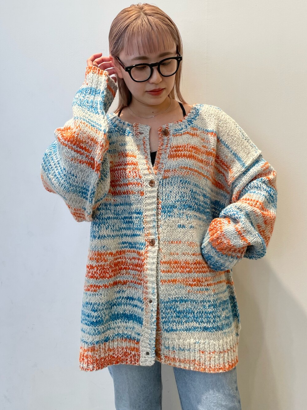 ホワイト系のカーディガン/ボレロ、ブラック系のバッグ、ブルー系のデニムパンツを着用したレディースの秋コーディネートの5枚目の写真