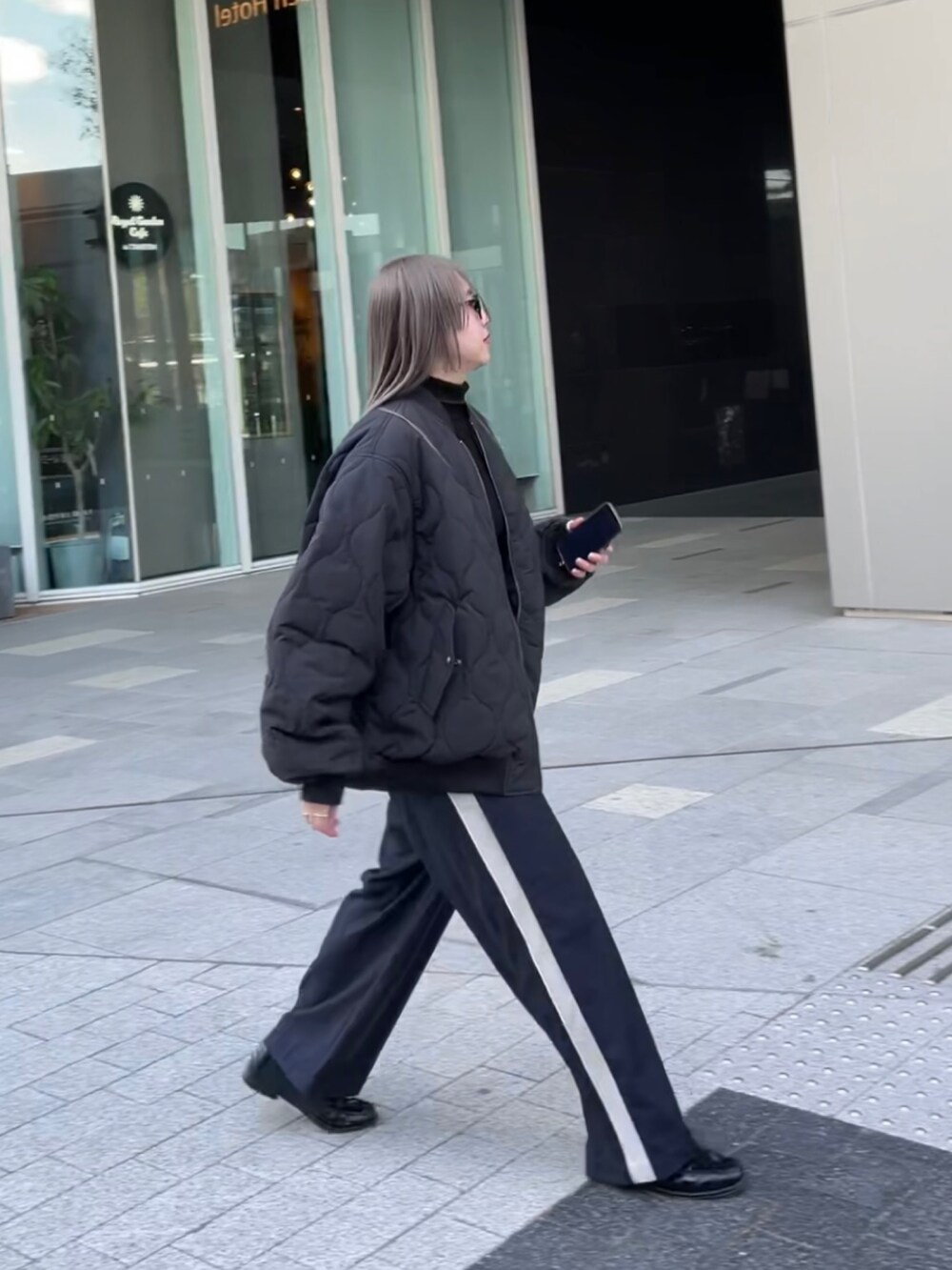 ブラック系のジャケット/アウター、ブラック系のニット/セーター、ブルー系のスラックスを着用したレディースの冬コーディネートの9枚目の写真