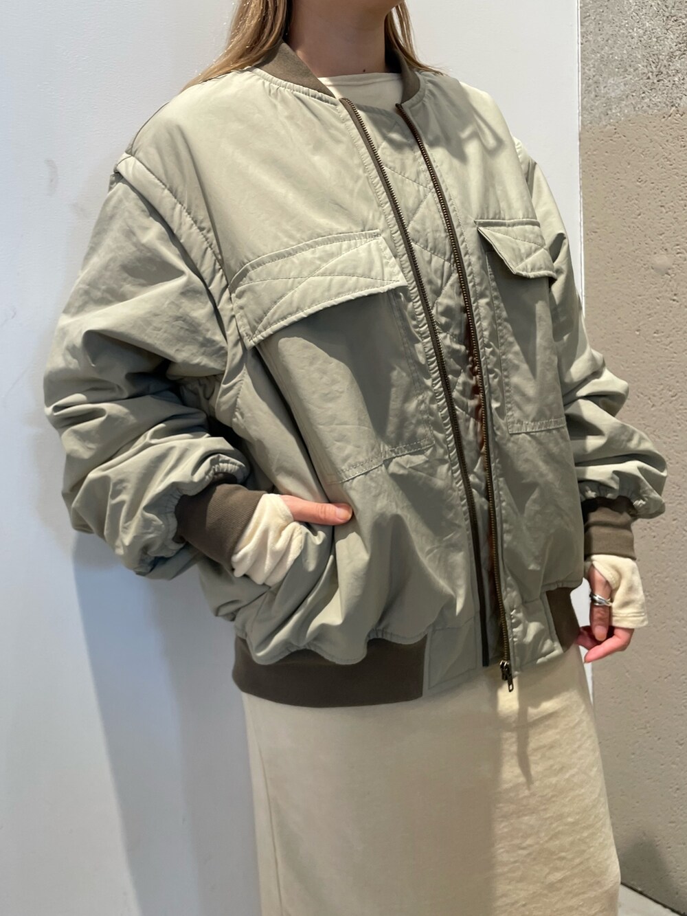 グリーン系のMA-1、ホワイト系のワンピース/ドレス、ブラウン系のシューズを着用したレディースの秋コーディネートの5枚目の写真