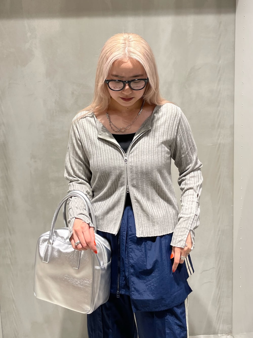 グレー系のカーディガン/ボレロ、ブルー系のスカート、ブルー系のスウェットパンツを着用したレディースの秋コーディネートの3枚目の写真