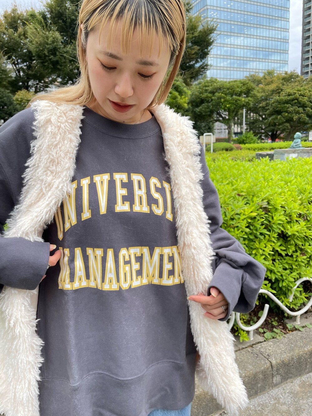 ホワイト系のベスト、グレー系のスウェット、ブルー系のデニムパンツを着用したレディースの秋コーディネートの8枚目の写真