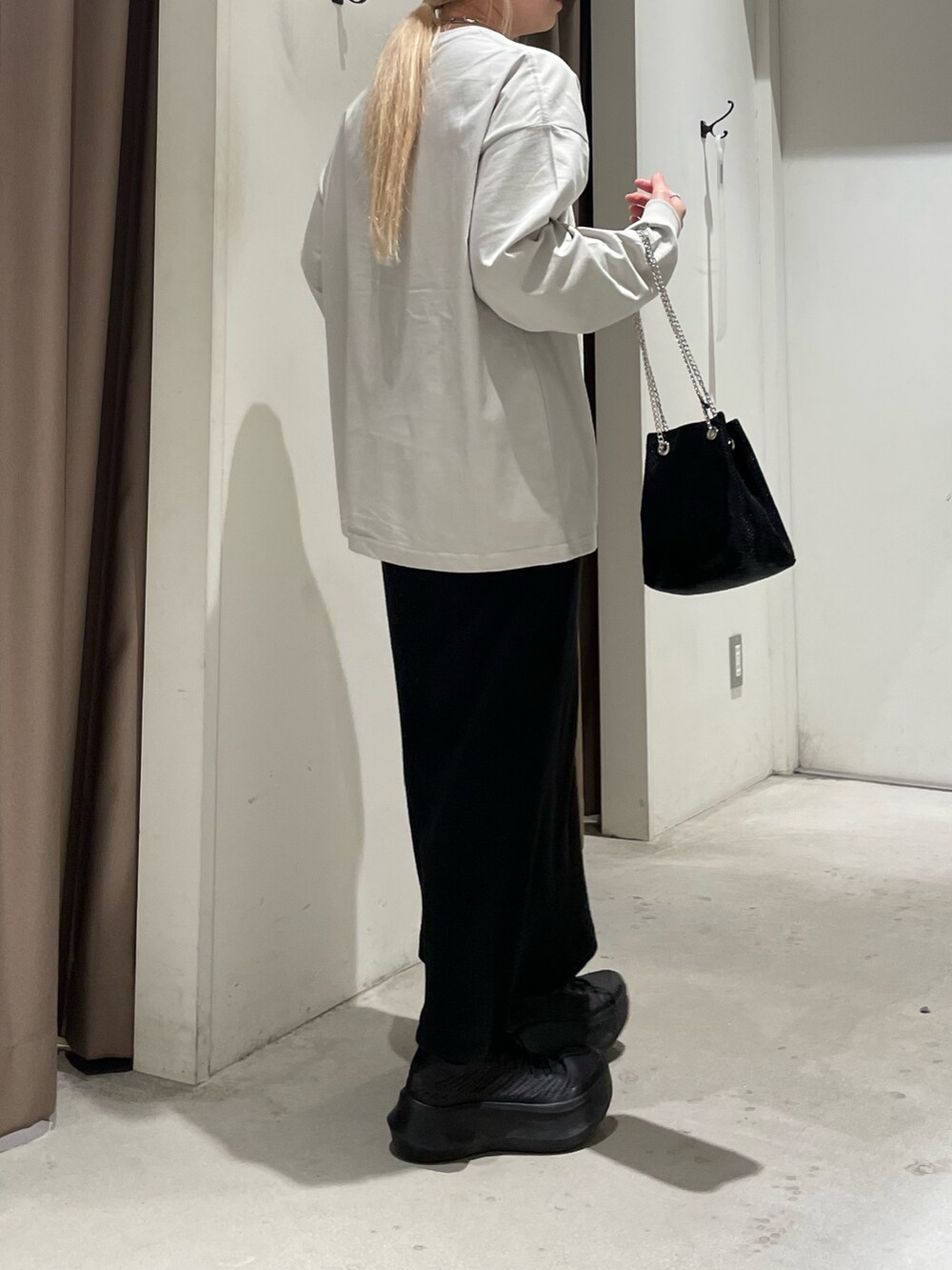 グレー系のTシャツ/カットソー、ブラック系のスカート、ブラック系のショルダーバッグを着用したレディースの春コーディネートの3枚目の写真