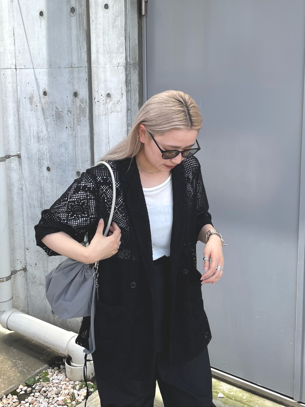 ブラック系のテーラードジャケット、グレー系のバッグ、ブラック系のサロペット/オーバーオールを着用したレディースの夏コーディネートの4枚目の写真