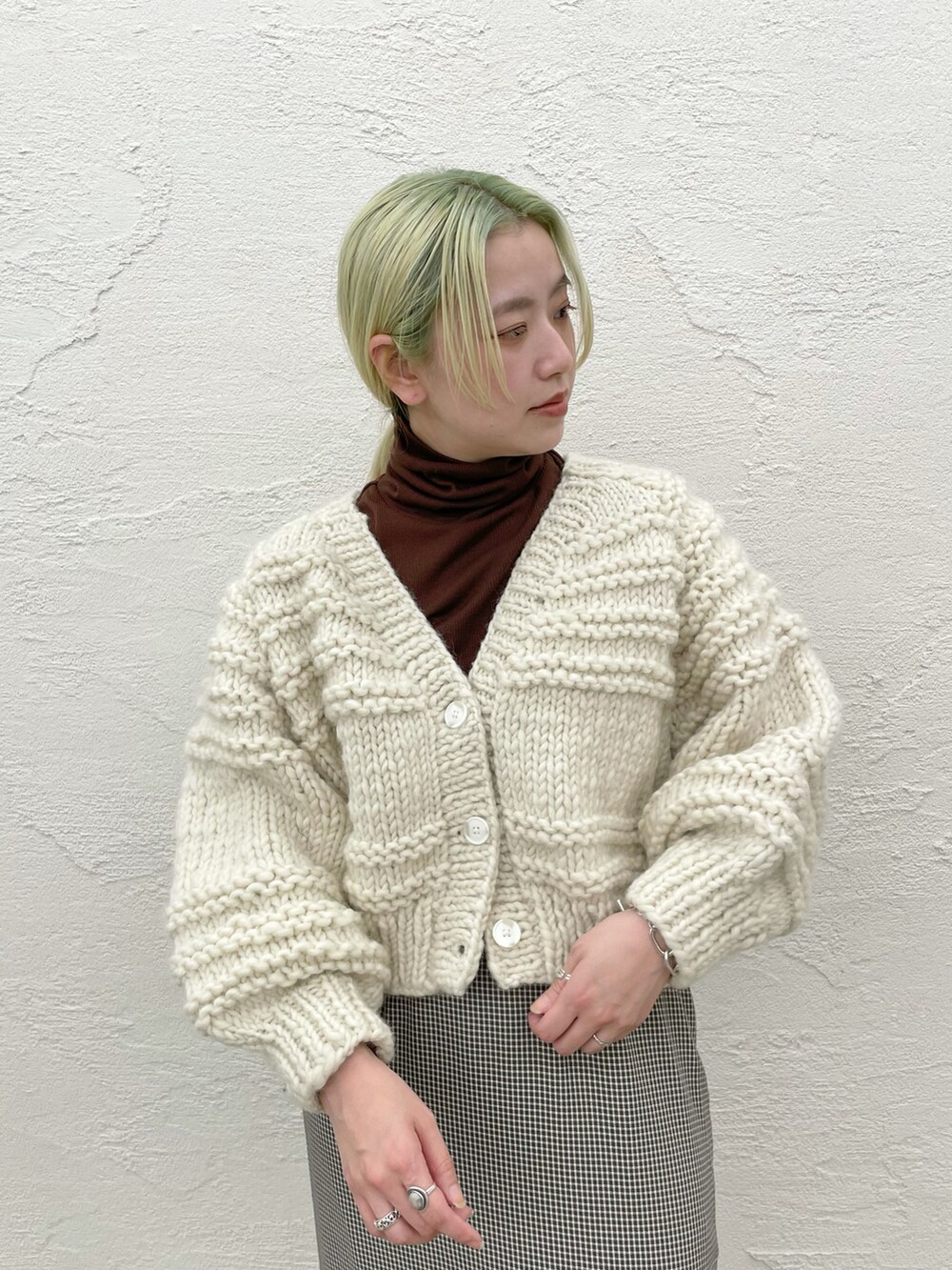 ホワイト系のカーディガン/ボレロ、グリーン系のスカートを着用したレディースの秋コーディネートの2枚目の写真