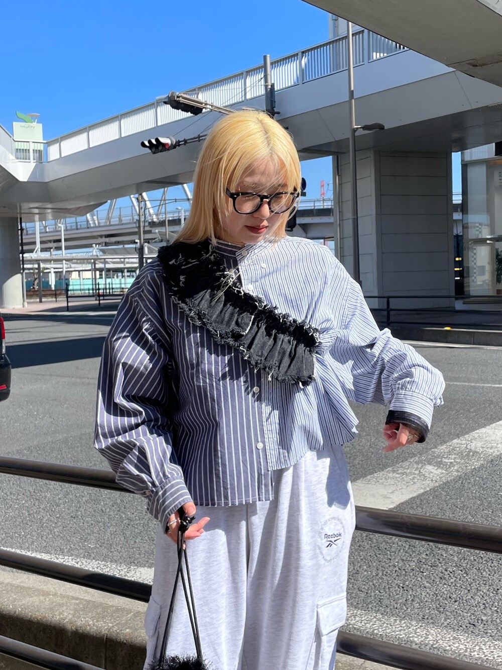 ブルー系のシャツ/ブラウス、ブラック系のデニムスカート、グレー系のパンツを着用したレディースの春コーディネートの5枚目の写真