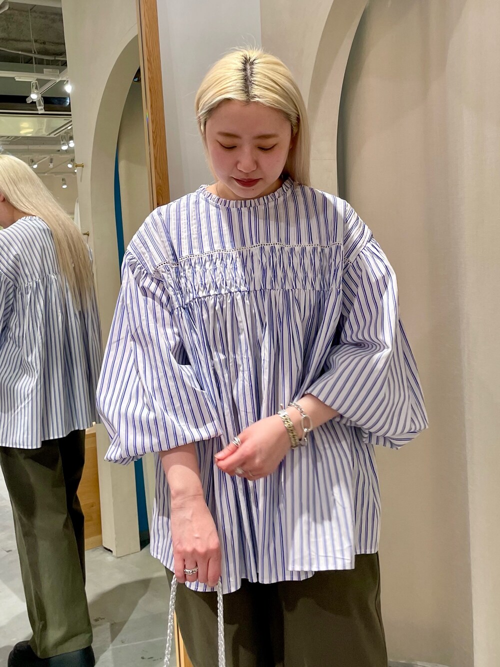 ブルー系のシャツ/ブラウス、グリーン系のチノパンツを着用したレディースの春コーディネートの5枚目の写真