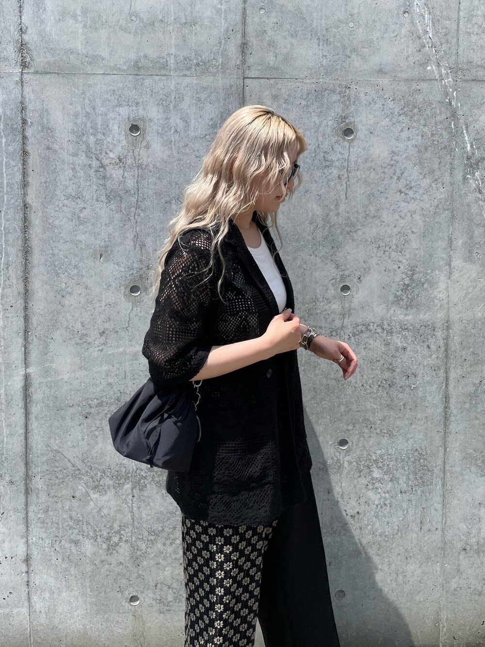 ブラック系のテーラードジャケット、ブラック系のスカート、ブラック系のショルダーバッグを着用したレディースの夏コーディネートの5枚目の写真