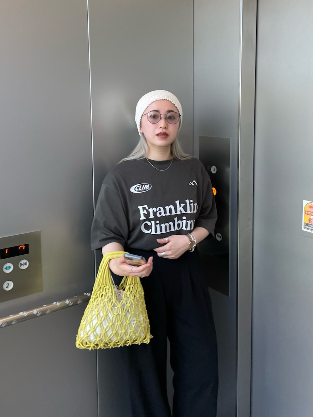 グレー系のTシャツ/カットソー、イエロー系のバッグ、ホワイト系のニットキャップ/ビーニーを着用したレディースの夏コーディネートの4枚目の写真