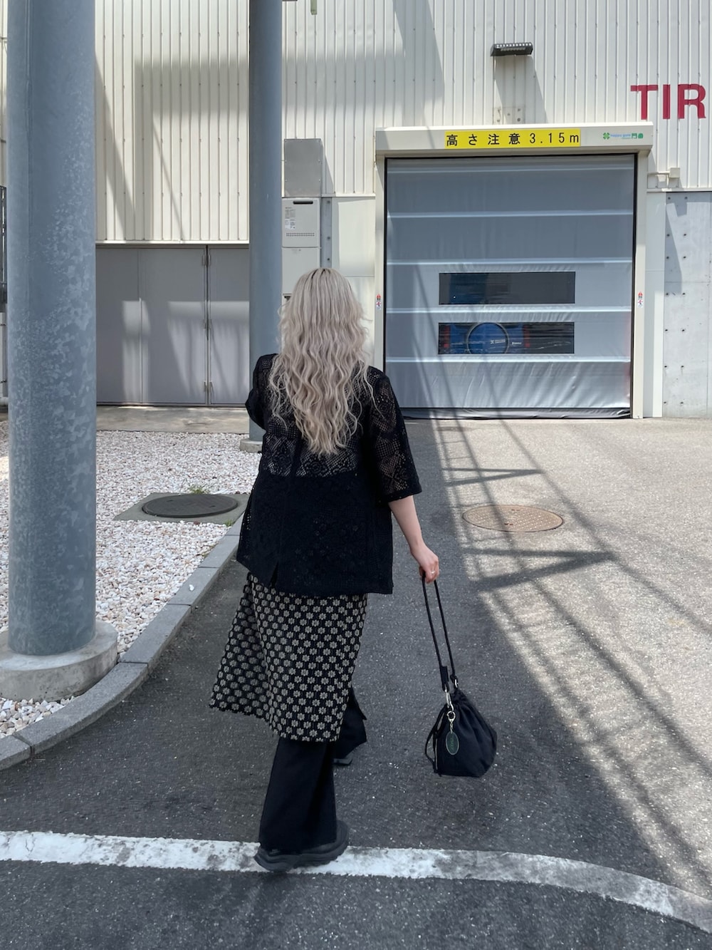 ブラック系のテーラードジャケット、ブラック系のスカート、ブラック系のショルダーバッグを着用したレディースの夏コーディネートの4枚目の写真