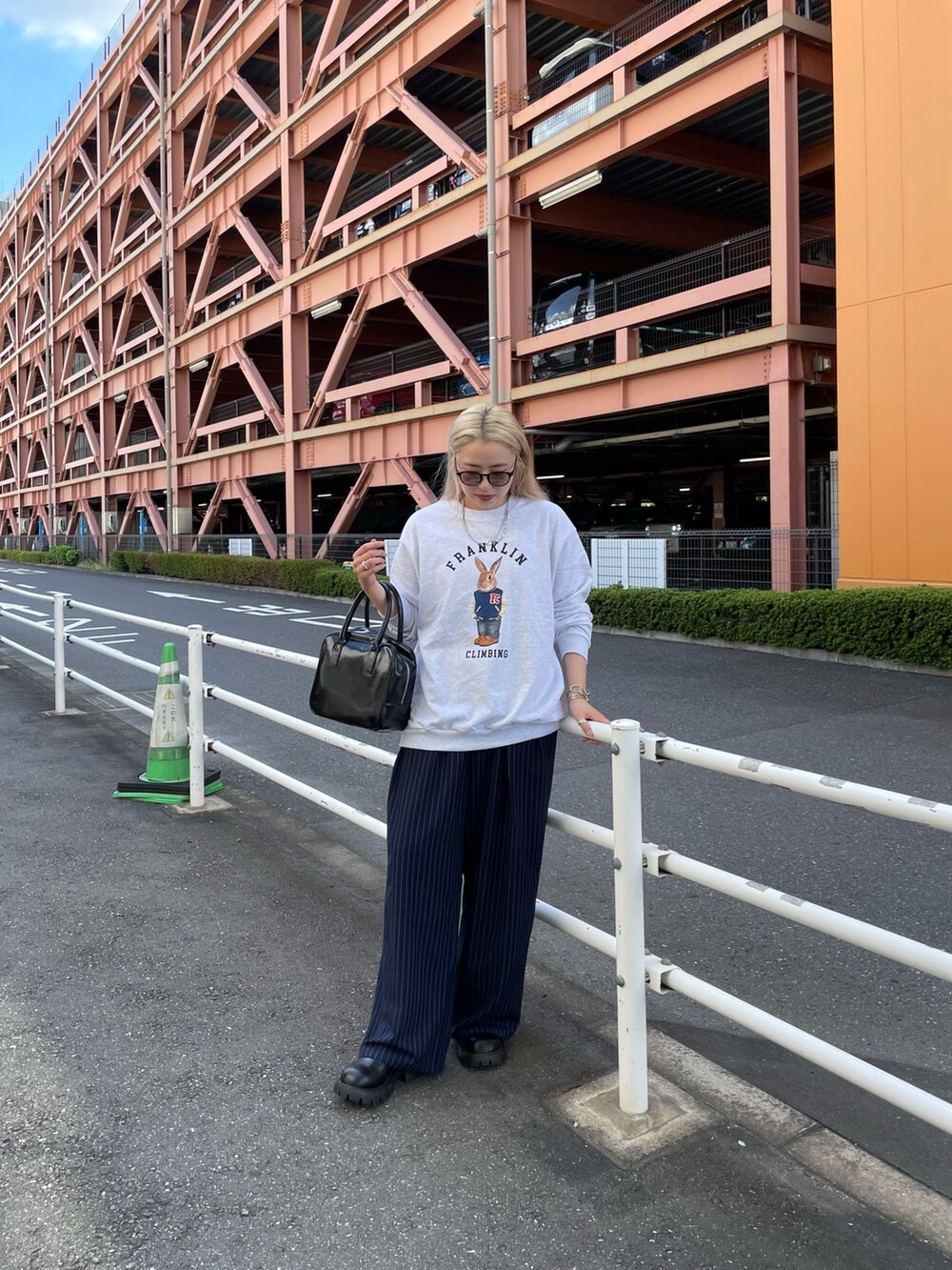 ブルー系のスラックス、ブラック系のボストンバッグ、グレー系のスウェットを着用したレディースの秋コーディネートの6枚目の写真