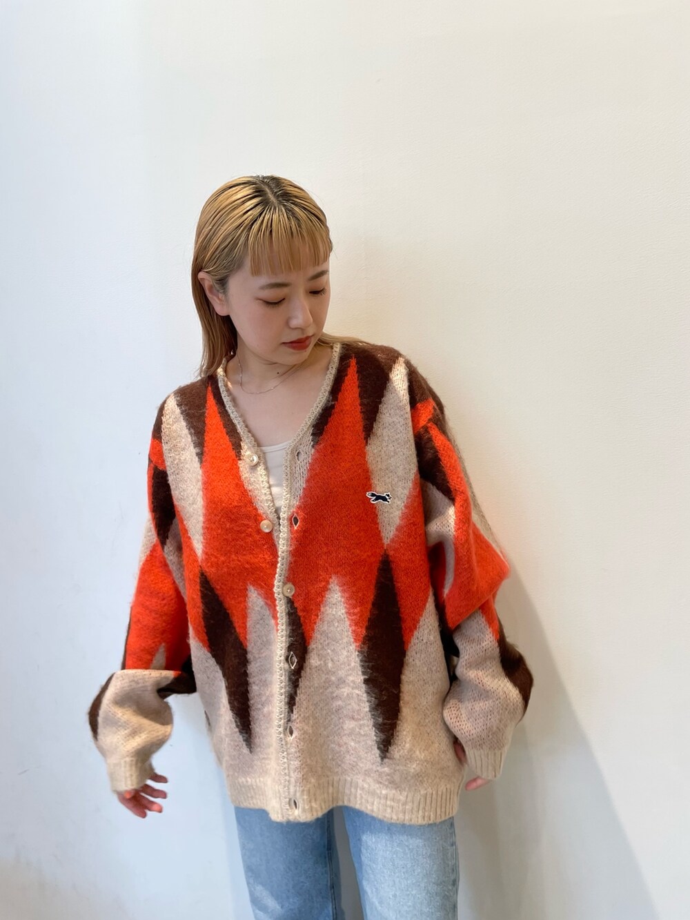 ホワイト系のカーディガン/ボレロ、ブルー系のデニムパンツを着用したレディースの秋コーディネートの4枚目の写真