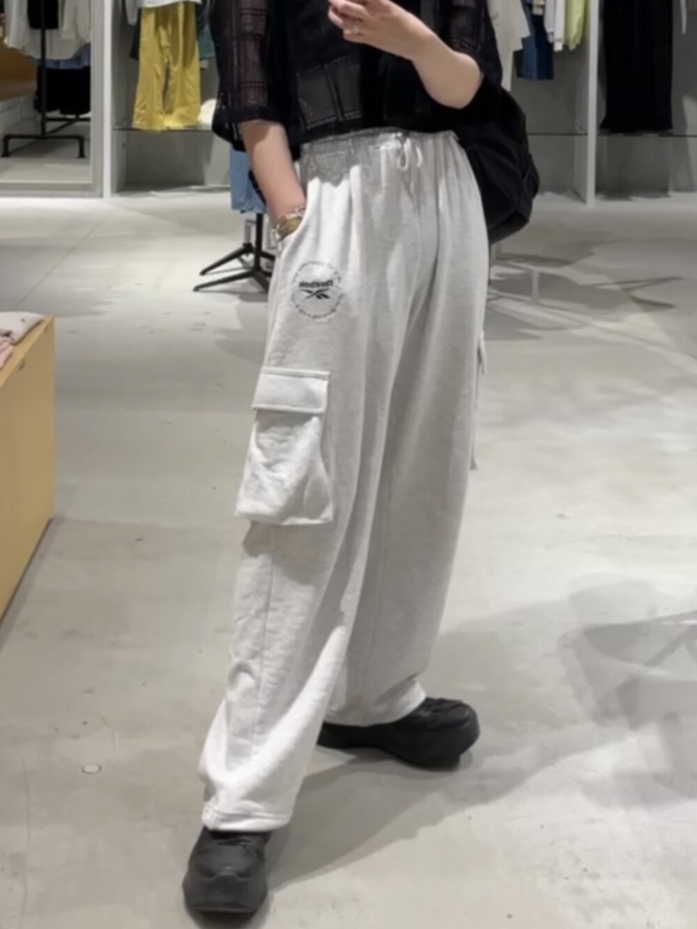 ブラック系のシャツ/ブラウス、グレー系のパンツを着用したレディースの夏コーディネートの4枚目の写真