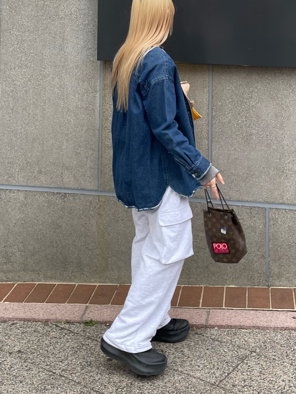 ブラック系のスニーカー、グレー系のパンツを着用したレディースの春コーディネートの5枚目の写真