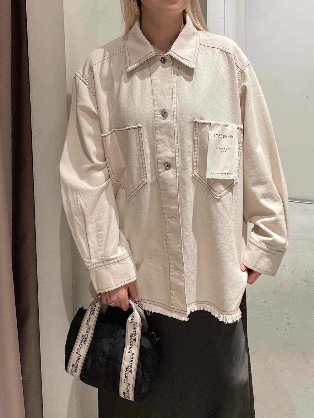 ホワイト系のデニムジャケット、グレー系のスカートを着用したレディースの春コーディネートの4枚目の写真