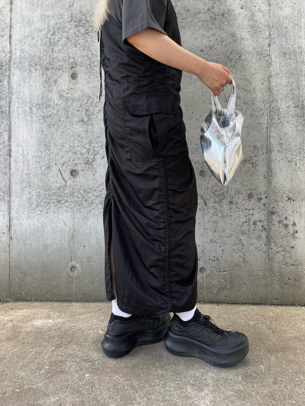 ブラック系のワンピース、グレー系のTシャツ/カットソー、シルバー系のトートバッグを着用したレディースの夏コーディネートの7枚目の写真
