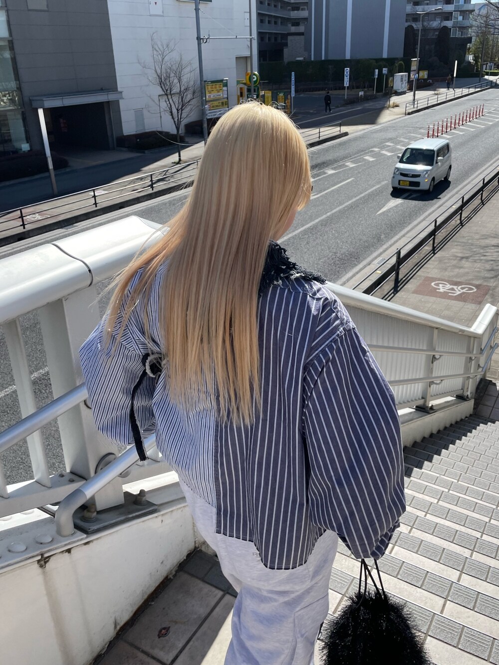 ブルー系のシャツ/ブラウス、ブラック系のデニムスカート、グレー系のパンツを着用したレディースの春コーディネートの6枚目の写真