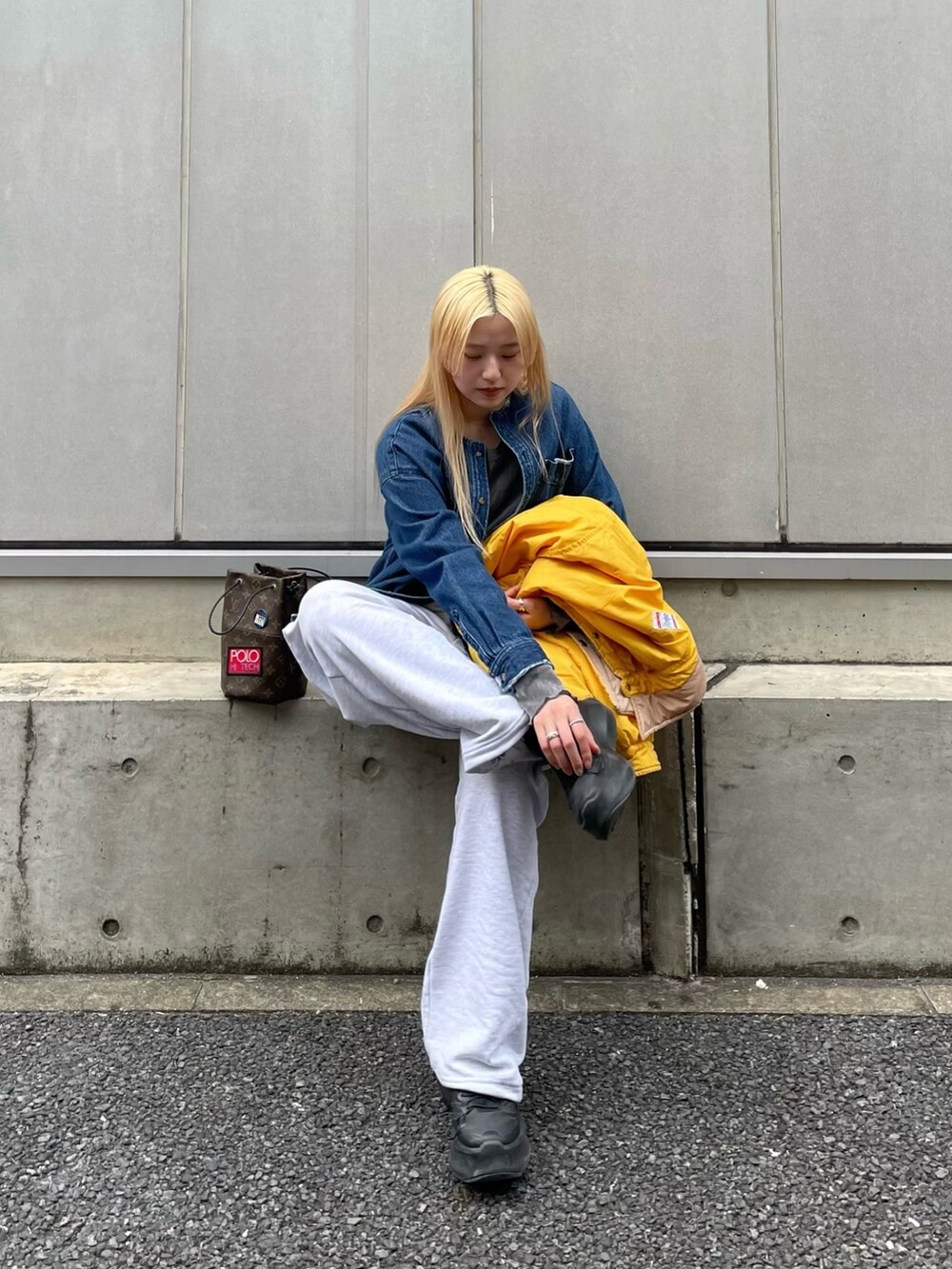 ブラック系のスニーカー、グレー系のパンツを着用したレディースの春コーディネートの4枚目の写真