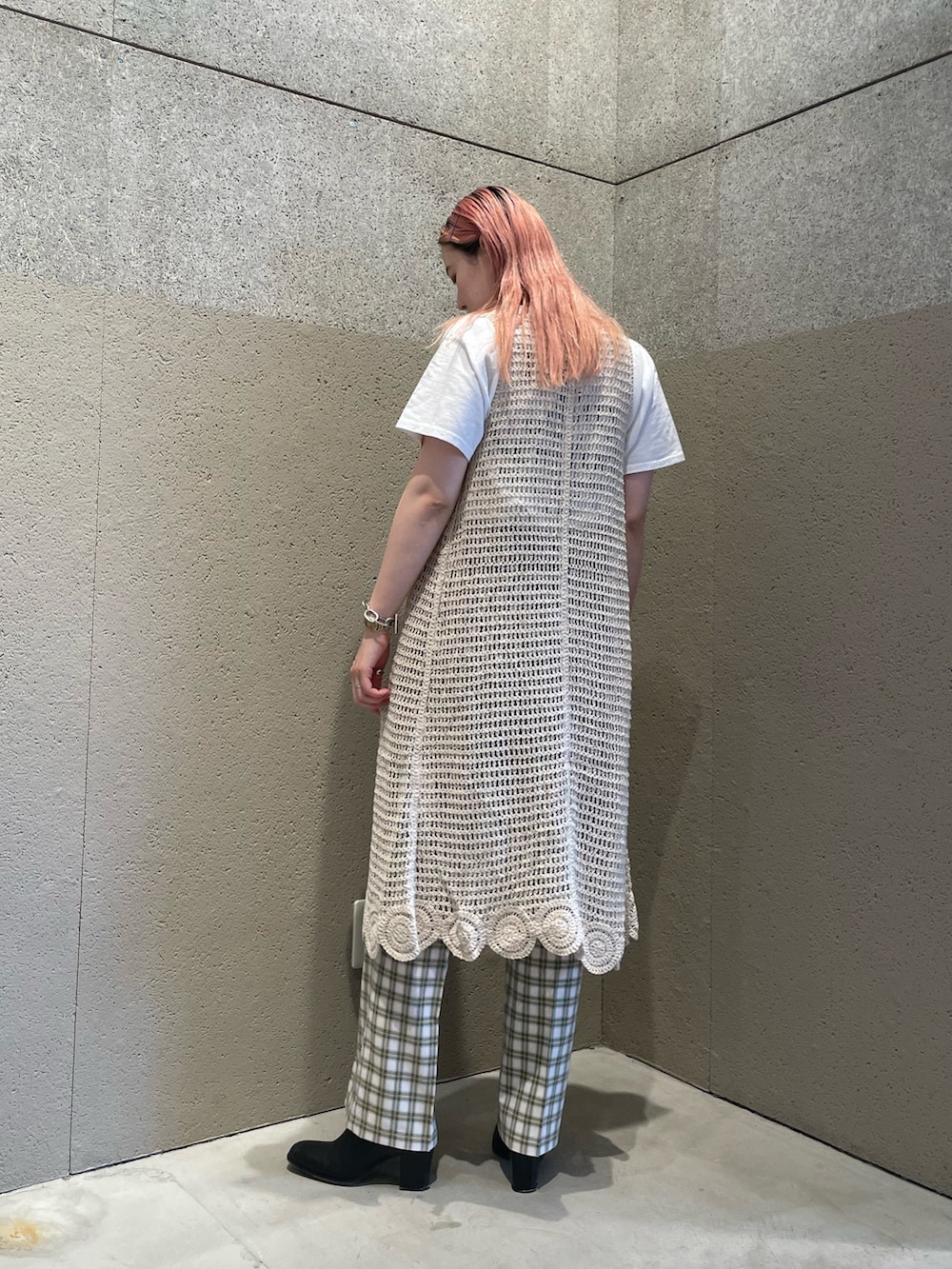 ホワイト系のニット/セーター、ホワイト系のTシャツ/カットソー、ベージュ系のスラックスを着用したレディースの夏コーディネートの2枚目の写真