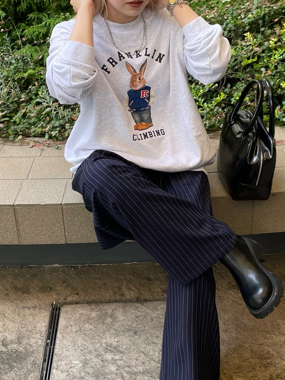 ブルー系のスラックス、ブラック系のボストンバッグ、グレー系のスウェットを着用したレディースの秋コーディネートの4枚目の写真