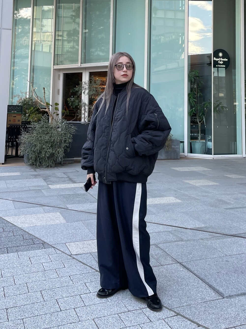 ブラック系のジャケット/アウター、ブラック系のニット/セーター、ブルー系のスラックスを着用したレディースの冬コーディネートの7枚目の写真