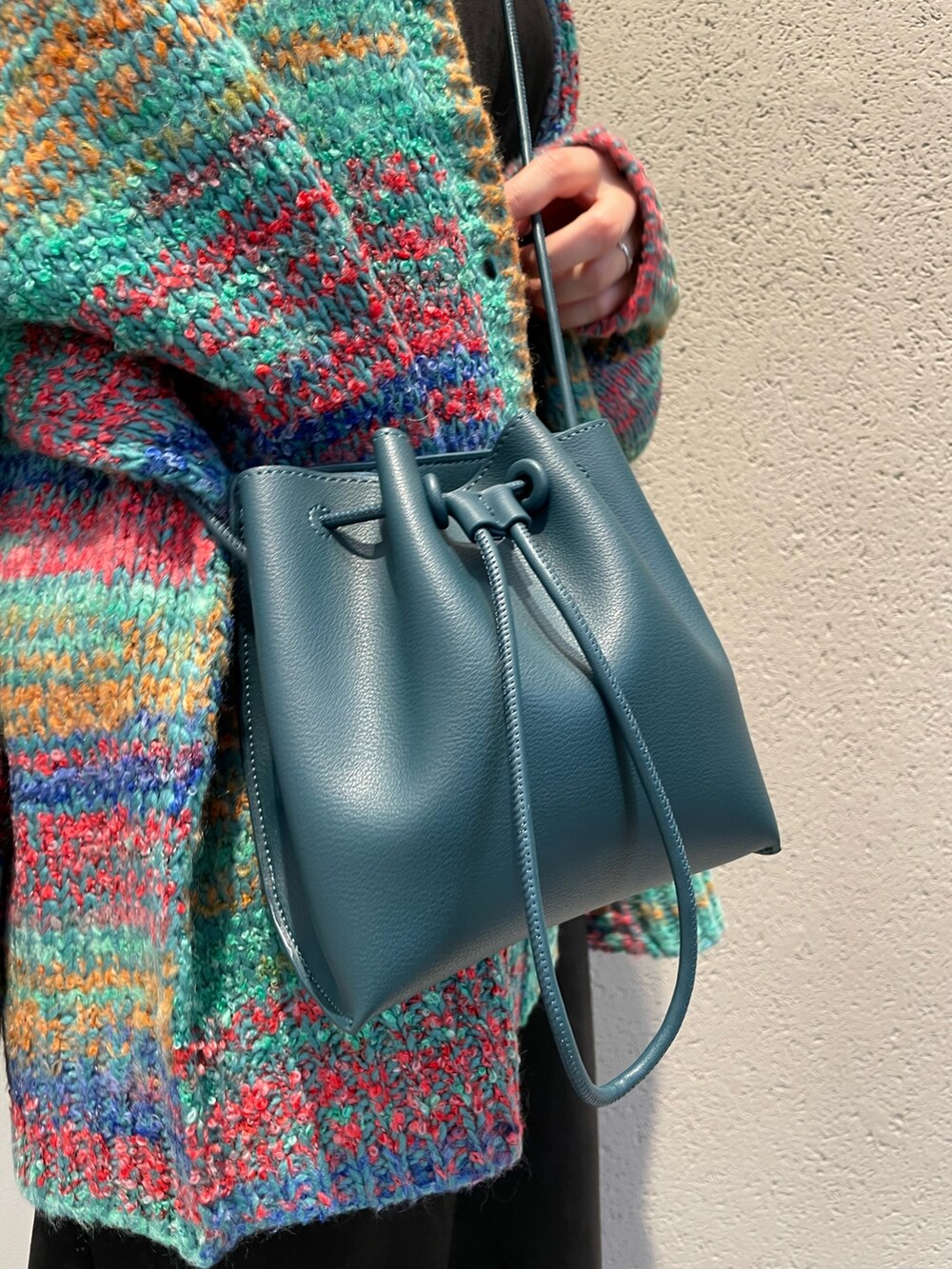 グリーン系のカーディガン/ボレロ、ブラック系のワンピース、ブルー系のショルダーバッグを着用したレディースの秋コーディネートの10枚目の写真