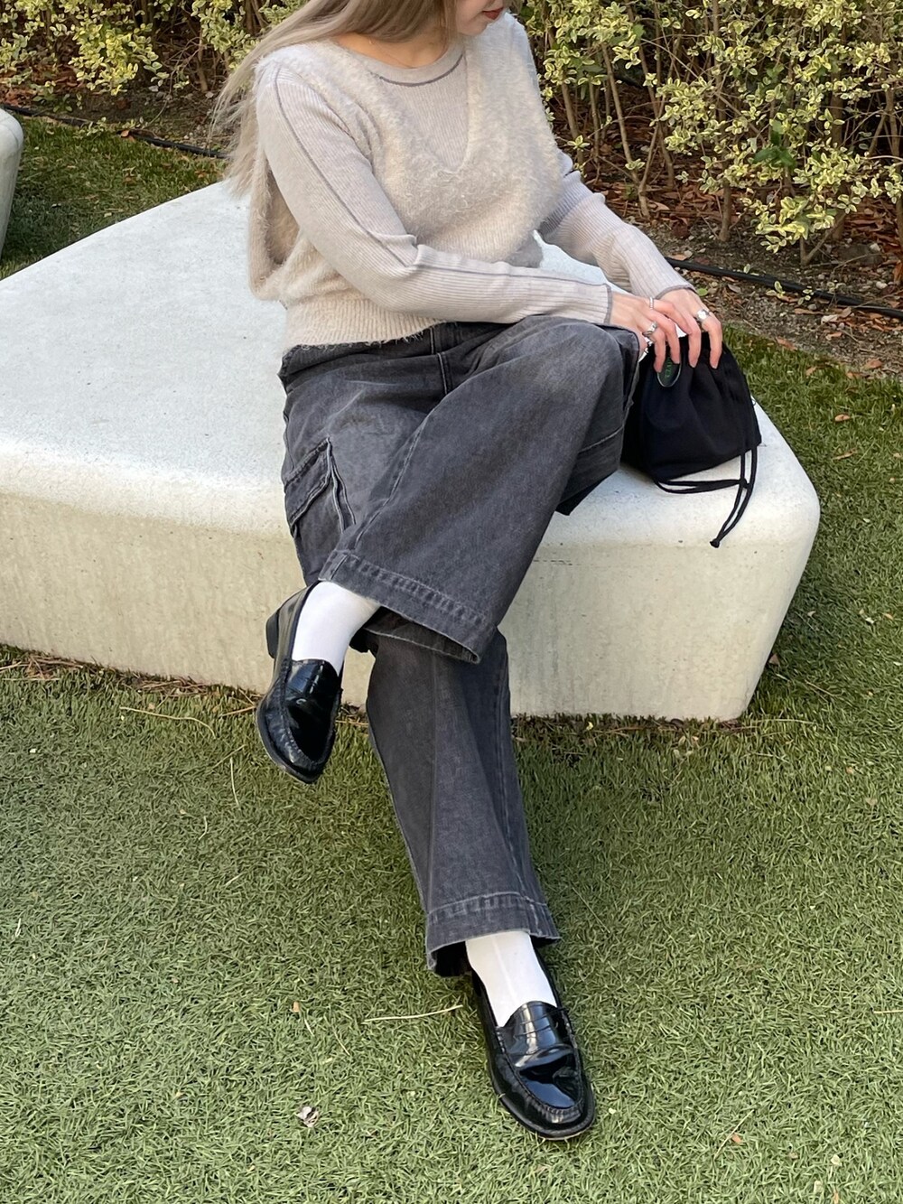 グレー系のベスト、グレー系のニット/セーター、ブラック系のバッグを着用したレディースの冬コーディネートの5枚目の写真