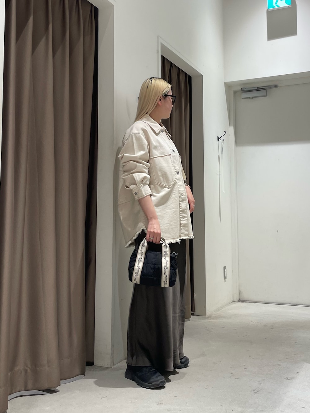 ホワイト系のデニムジャケット、グレー系のスカートを着用したレディースの春コーディネートの2枚目の写真