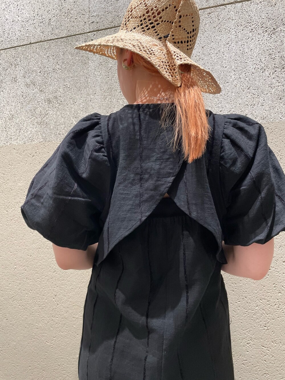 ブラック系のワンピース、グリーン系のかごバッグ、ブラック系のサンダルを着用したレディースの春コーディネートの4枚目の写真