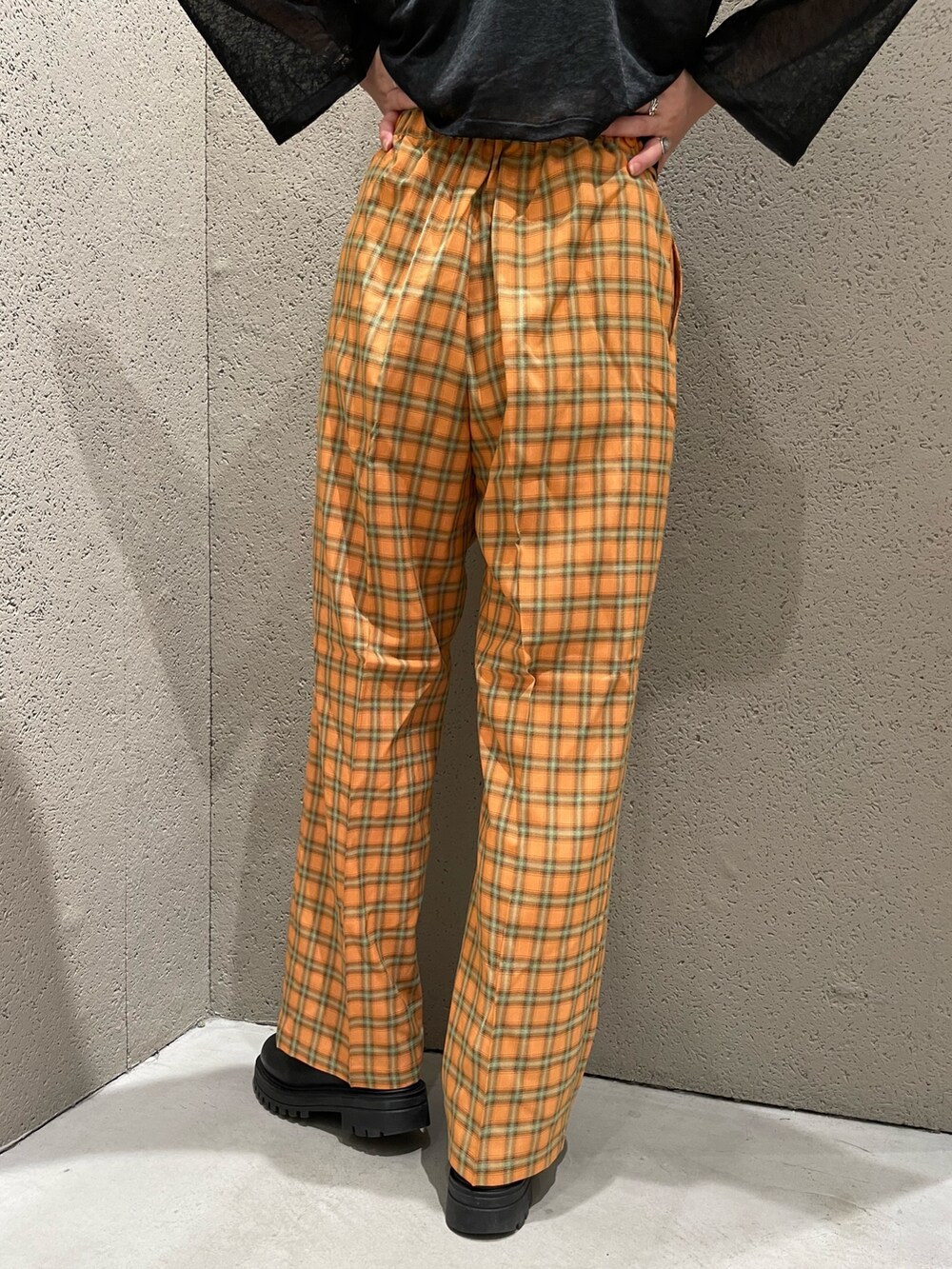 ブラック系のカーディガン/ボレロ、オレンジ系のスラックスを着用したレディースの夏コーディネートの5枚目の写真