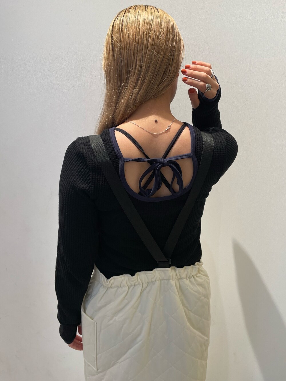 ブラック系のブルゾン、ブラック系のTシャツ/カットソー、ホワイト系のジャンパースカートを着用したレディースの秋コーディネートの5枚目の写真