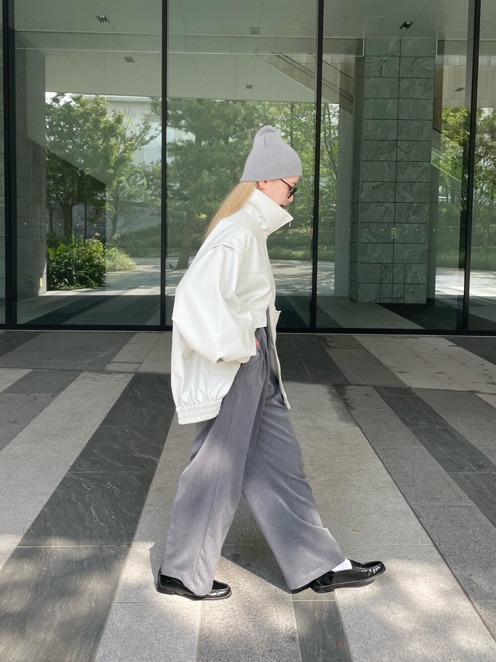 ホワイト系のジャケット/アウター、ホワイト系のTシャツ/カットソー、グレー系のスラックスを着用したレディースの秋コーディネートの6枚目の写真