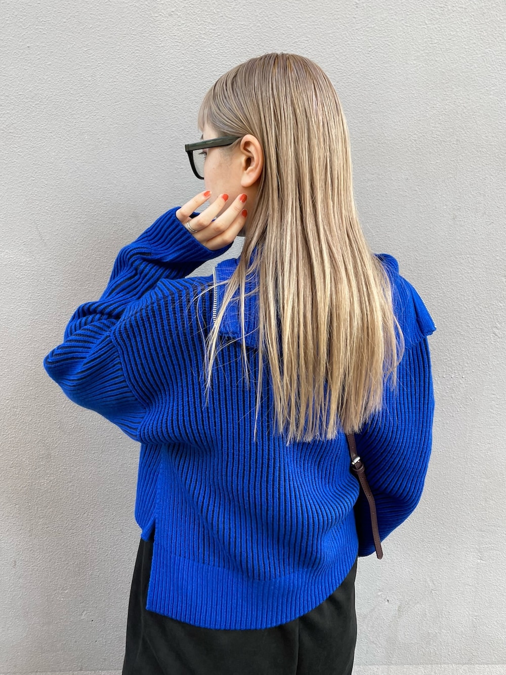 ブルー系のニット/セーター、ブラック系のワンピース、ブラック系のブーツを着用したレディースの秋コーディネートの5枚目の写真