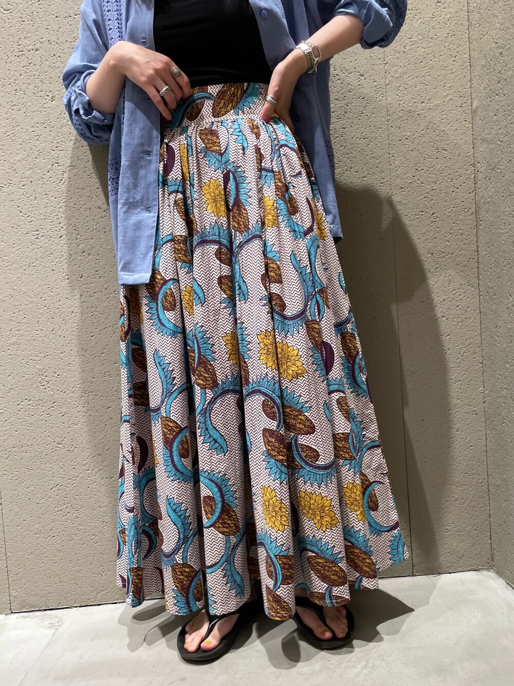 ブルー系のシャツ/ブラウス、ホワイト系のスカート、ベージュ系のかごバッグを着用したレディースの夏コーディネートの4枚目の写真