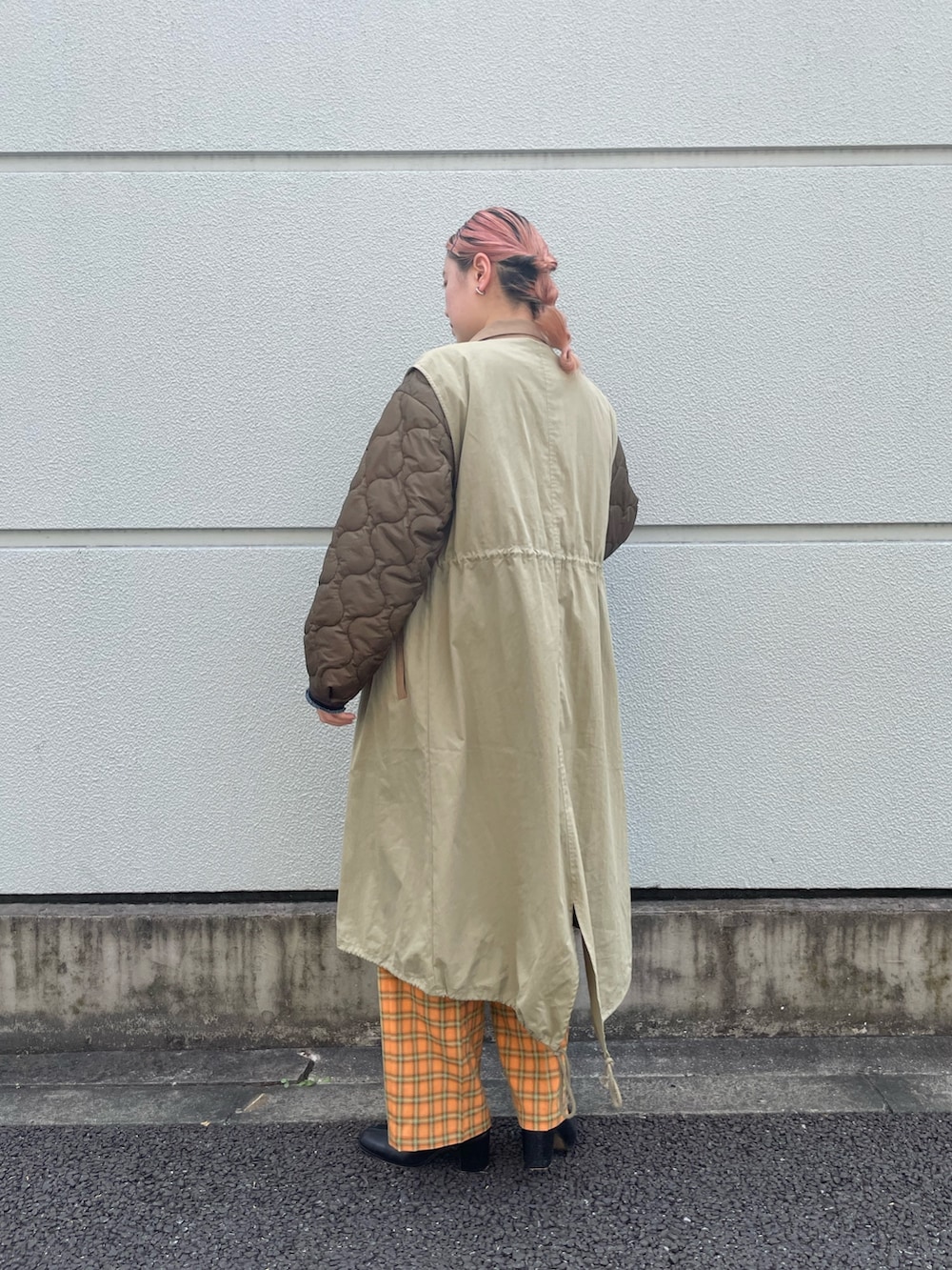 グリーン系のノーカラーコート、オレンジ系のスラックスを着用したレディースの夏コーディネートの2枚目の写真