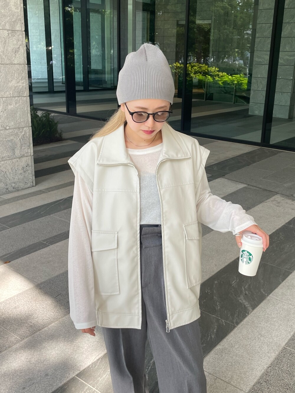 ホワイト系のジャケット/アウター、ホワイト系のTシャツ/カットソー、グレー系のスラックスを着用したレディースの秋コーディネートの7枚目の写真