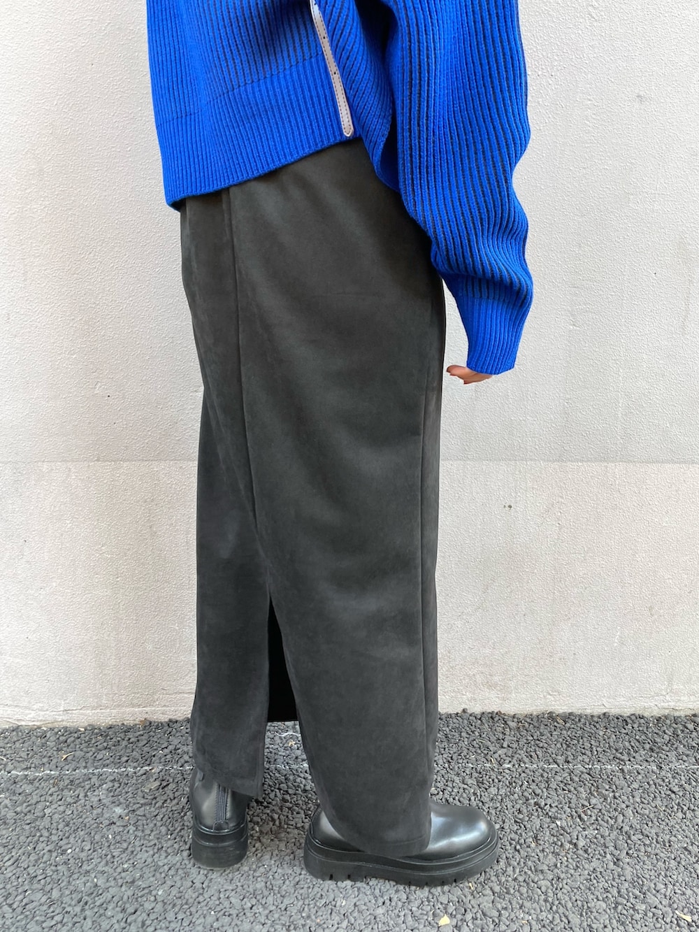 ブルー系のニット/セーター、ブラック系のワンピース、ブラック系のブーツを着用したレディースの秋コーディネートの7枚目の写真