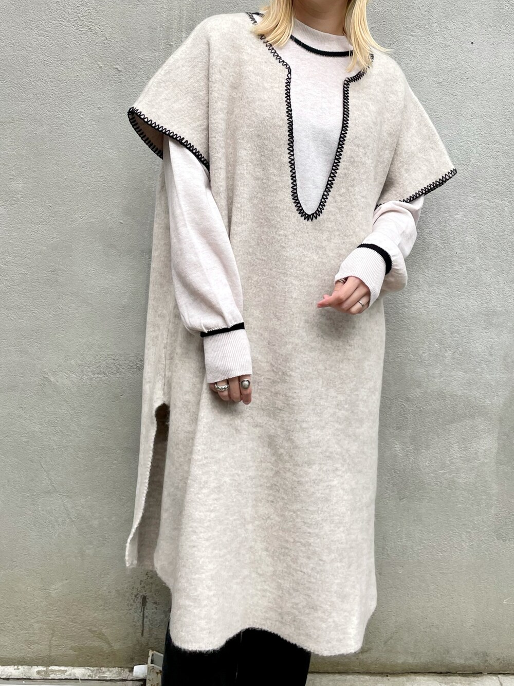 ホワイト系のニット/セーター、ブラック系のデニムパンツ、ブラック系のブーツを着用したレディースの秋コーディネートの4枚目の写真