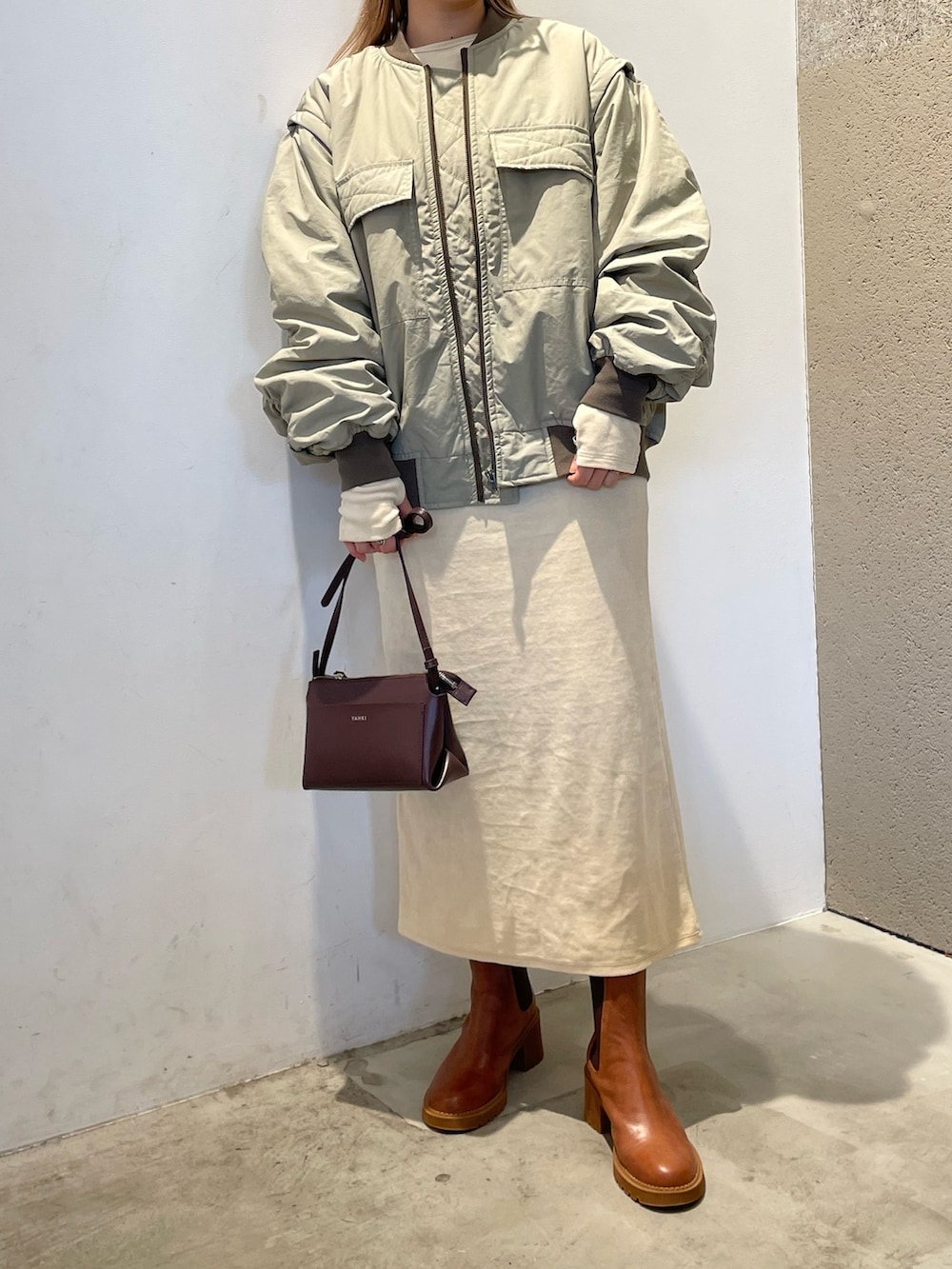 グリーン系のMA-1、ホワイト系のワンピース/ドレス、ブラウン系のシューズを着用したレディースの秋コーディネートの4枚目の写真