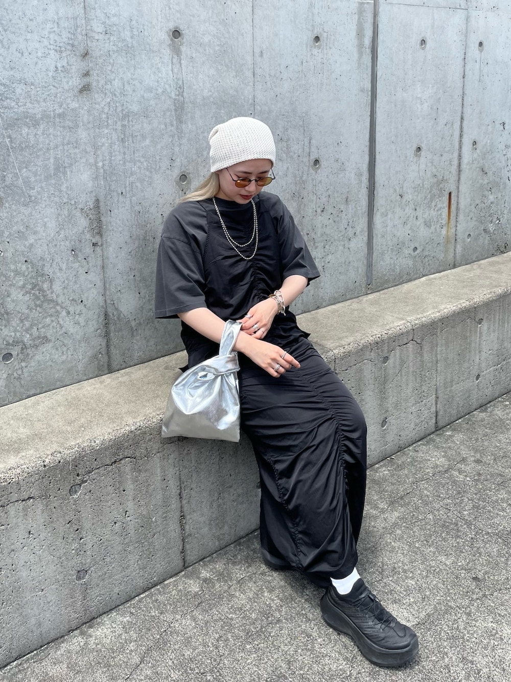 ブラック系のワンピース、グレー系のTシャツ/カットソー、シルバー系のトートバッグを着用したレディースの夏コーディネートの2枚目の写真