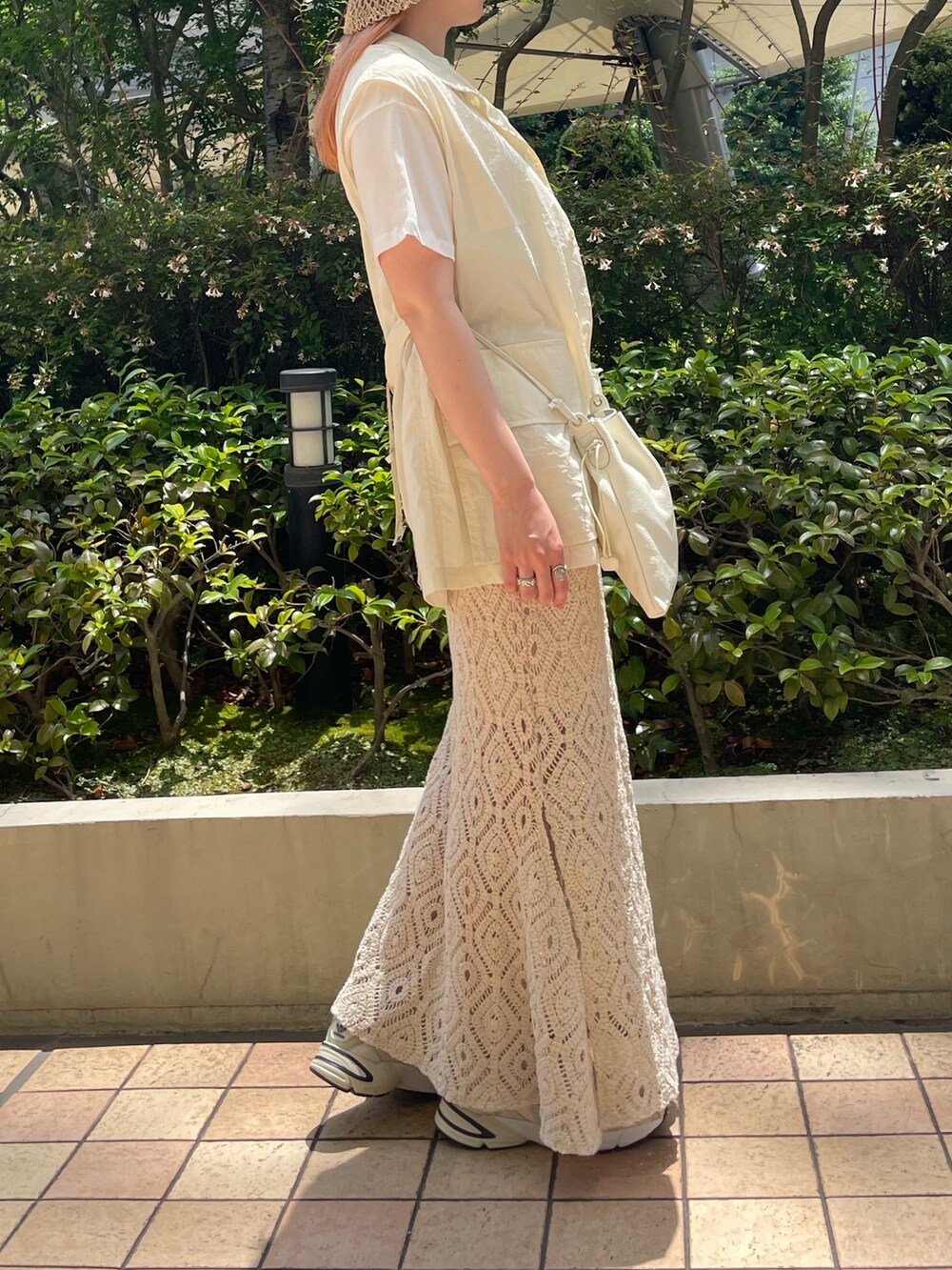 ホワイト系のベスト、ホワイト系のTシャツ/カットソー、ホワイト系のスカートを着用したレディースの夏コーディネートの4枚目の写真