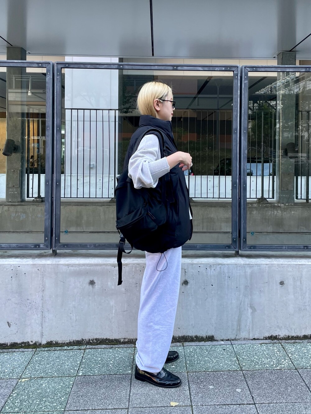 ブラック系のダウンベスト、ホワイト系のニット/セーター、グレー系のスウェットパンツを着用したレディースの冬コーディネートの7枚目の写真