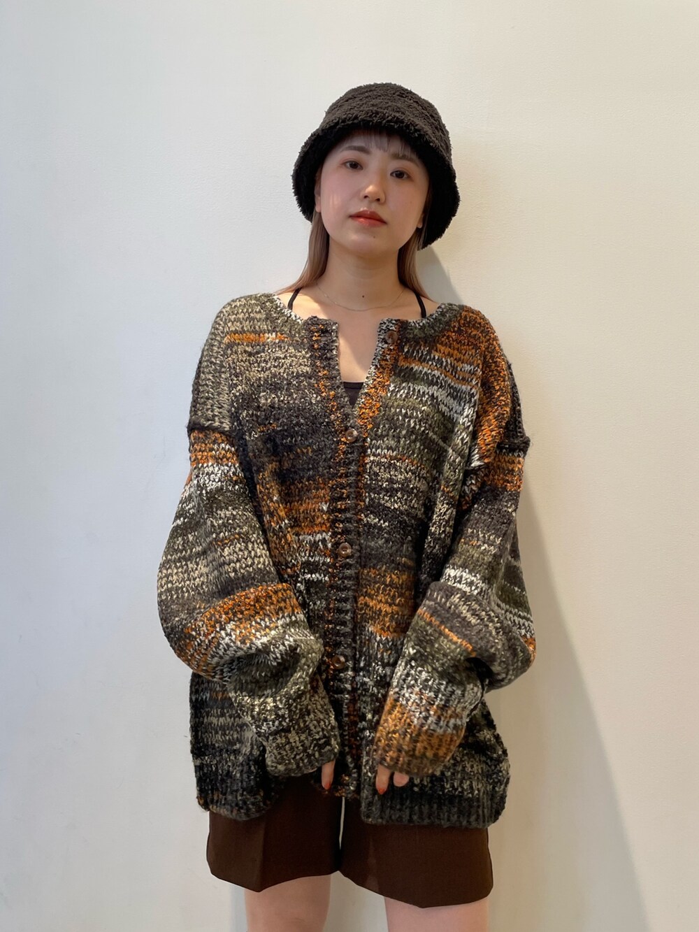 グリーン系のカーディガン/ボレロ、ブラウン系のその他パンツ、ブラック系のブーツを着用したレディースの秋コーディネートの3枚目の写真