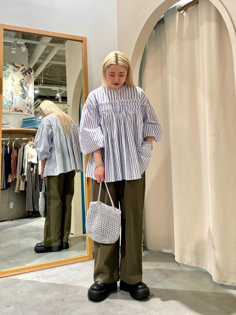 ブルー系のシャツ/ブラウス、グリーン系のチノパンツを着用したレディースの春コーディネートの2枚目の写真