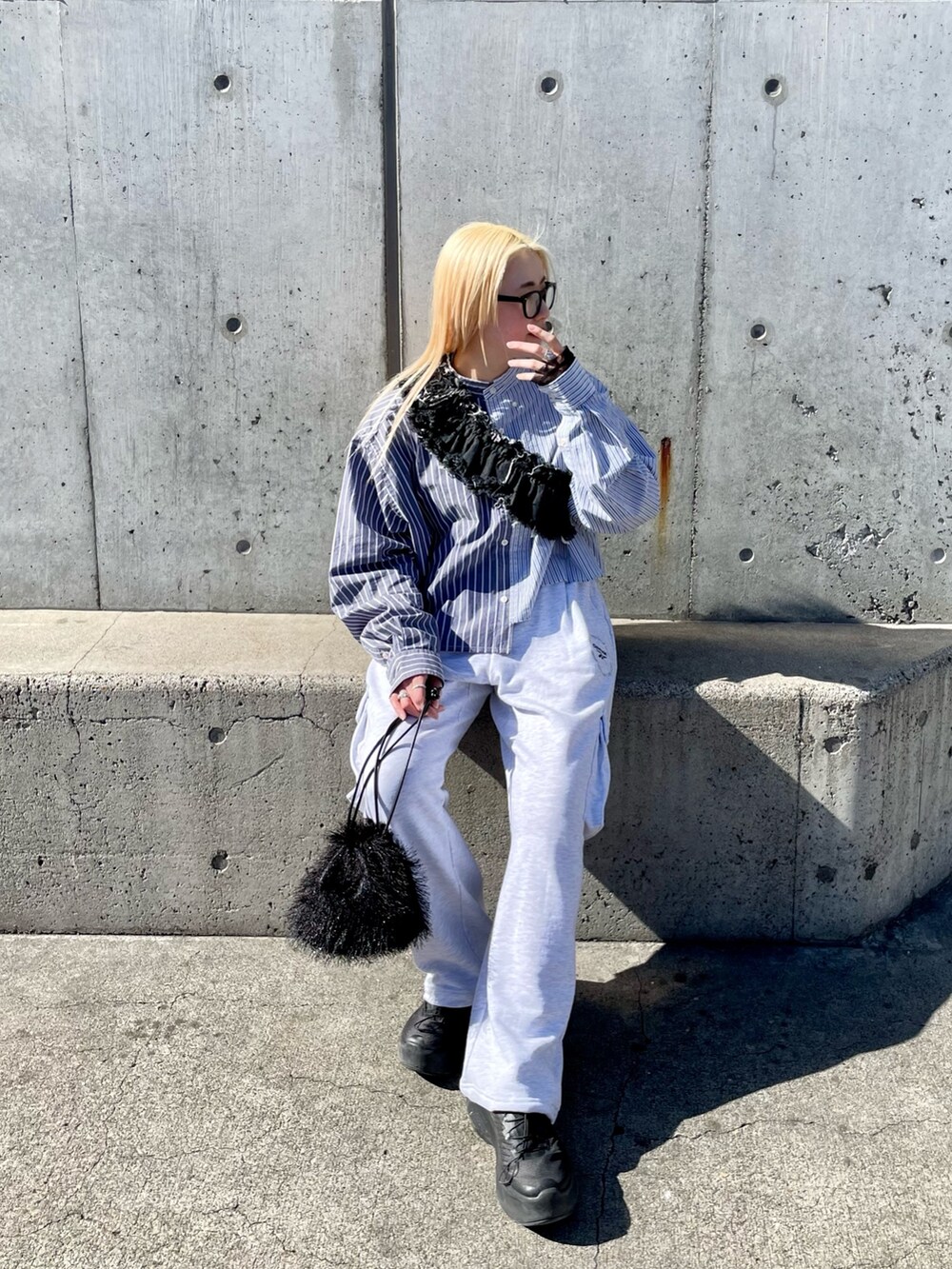 ブルー系のシャツ/ブラウス、ブラック系のデニムスカート、グレー系のパンツを着用したレディースの春コーディネートの3枚目の写真