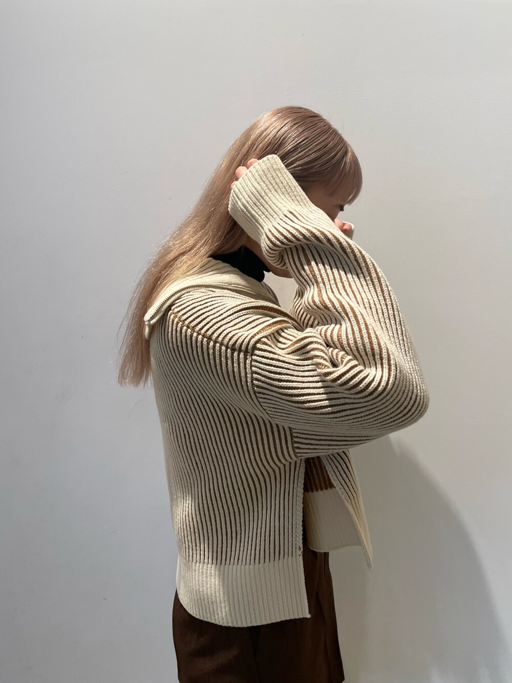 ベージュ系のニット/セーター、ブラウン系のその他パンツ、ブラック系のブーツを着用したレディースの秋コーディネートの5枚目の写真