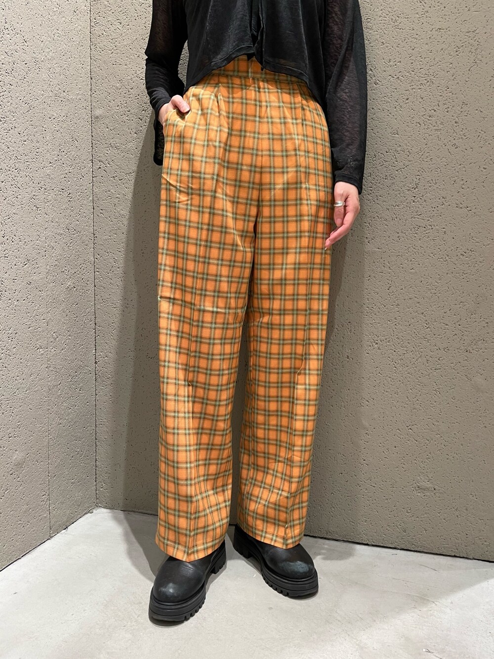 ブラック系のカーディガン/ボレロ、オレンジ系のスラックスを着用したレディースの夏コーディネートの4枚目の写真