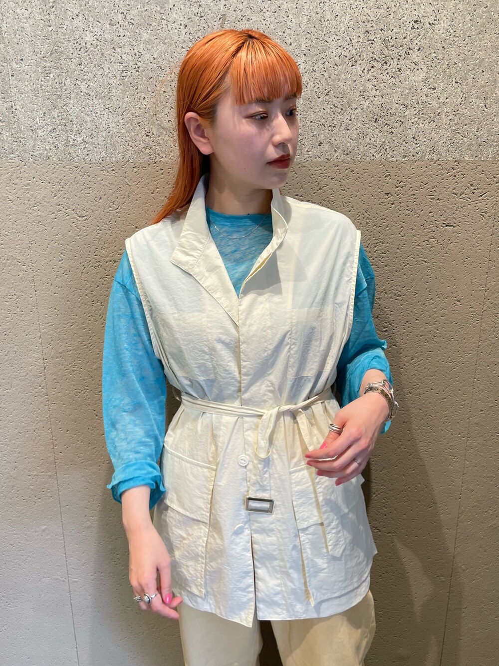 ホワイト系のベスト、ブルー系のTシャツ/カットソー、イエロー系のデニムパンツを着用したレディースの夏コーディネートの2枚目の写真